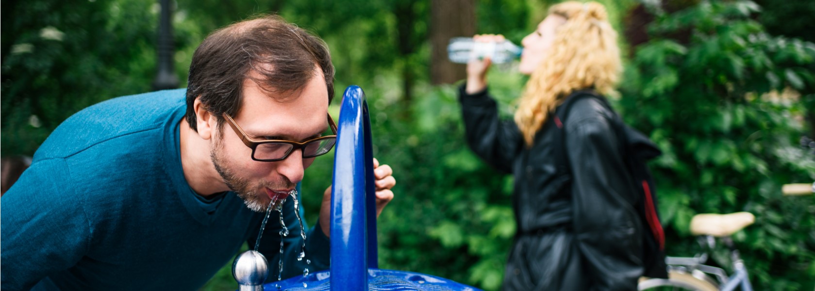 Trinkwasser ist lebenswichtig Zwei Radfahrer, die eine Pause machen und Wasser trinken