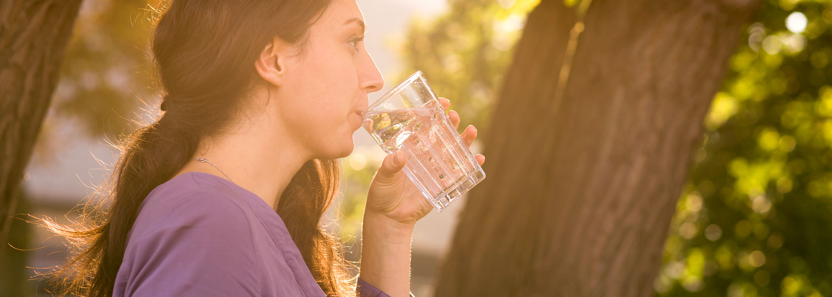 Wasser aus und für Thüringen Eine Frau, die ein Glas Wasser im Wald trinkt