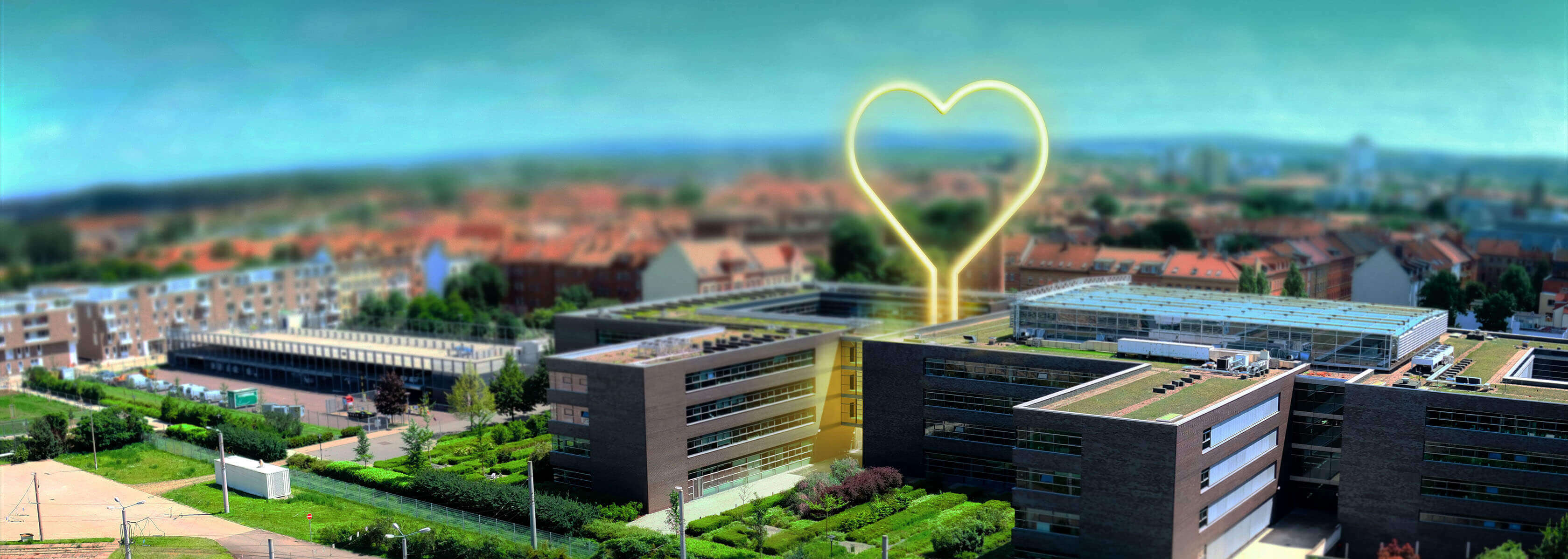 Service der SWE Energie für Erfurt Eine Drohnenaufnahme des Hauptsitzes der SWE Energie GmbH mit einem leuchtenden Neonherz darüber