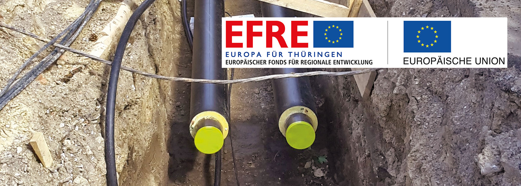 EFRE-Förderprogramme der SWE Energie GmbH Graben mit zu verlegenden Rohren für Fernwärme in Erfurt mit EFRE-Plakette